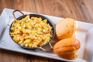 BONO BREAD AND SCRAMBLED EGGS IN A SKILLET