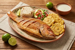 Pescado frito con arroz de coco, patacones y ensalada en Barranquilla.